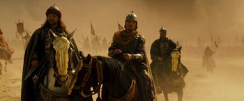 Movie still from “Prince of Persia: The Sands of Time” (2010), directed by Mike Newell – A group of men riding on the backs of horses; Wide shot, Low angle