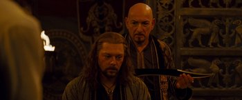 Movie still from “Prince of Persia: The Sands of Time” (2010), directed by Mike Newell – A man with long hair standing next to another man with long hair; Medium shot, Over the shoulder angle