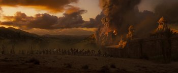 Movie still from “Prince of Persia: The Sands of Time” (2010), directed by Mike Newell – A group of people riding horses near a burning building; Extreme Wide shot, High angle