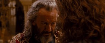 Movie still from “Prince of Persia: The Sands of Time” (2010), directed by Mike Newell – An old man with a beard and a long white beard; Close Up shot, Over the shoulder angle