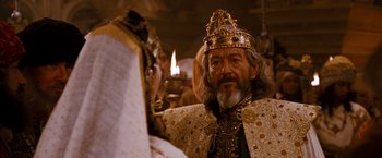 Movie still from “Prince of Persia: The Sands of Time” (2010), directed by Mike Newell – An old man dressed as a king with a crown on; Close Up shot, Over the shoulder angle
