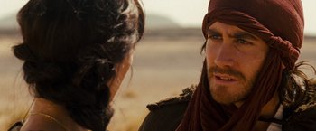 Movie still from “Prince of Persia: The Sands of Time” (2010), directed by Mike Newell – A man and a woman are talking in a desert setting; Close Up shot, Over the shoulder angle