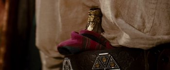 A bottle of wine on top of a purse