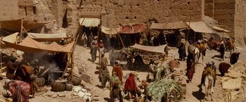 Movie still from “Prince of Persia: The Sands of Time” (2010), directed by Mike Newell – A group of people standing around in a dirt area; Extreme Wide shot, High angle