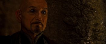 Movie still from “Prince of Persia: The Sands of Time” (2010), directed by Mike Newell – An older man with a bald head and a goatee; Close Up shot, Over the shoulder angle