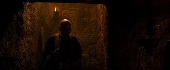 Movie still from “Prince of Persia: The Sands of Time” (2010), directed by Mike Newell – A man standing in front of a wall holding a camera; Medium shot, High angle