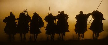 Movie still from “Prince of Persia: The Sands of Time” (2010), directed by Mike Newell – A group of people riding on the backs of horses; Wide shot, Low angle