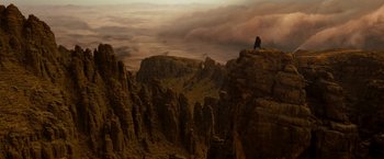 Movie still from “Prince of Persia: The Sands of Time” (2010), directed by Mike Newell – A person sitting on top of a rock on top of a mountain; Extreme Wide shot, High angle