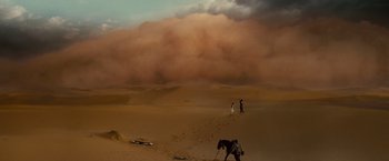 Movie still from “Prince of Persia: The Sands of Time” (2010), directed by Mike Newell – Two people are standing in the sand with a horse; Extreme Wide shot, Low angle