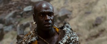 Movie still from “Prince of Persia: The Sands of Time” (2010), directed by Mike Newell – A man in a leopard print jacket and a yellow and black outfit; Close Up shot, Low angle