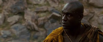 Movie still from “Prince of Persia: The Sands of Time” (2010), directed by Mike Newell – A man in a yellow shirt and a yellow necklace; Close Up shot, Low angle