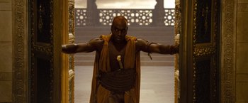 Movie still from “Prince of Persia: The Sands of Time” (2010), directed by Mike Newell – A man dressed in a costume standing in front of a wall; Medium shot, High angle