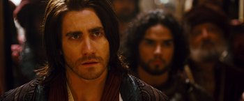 Movie still from “Prince of Persia: The Sands of Time” (2010), directed by Mike Newell – A man with long hair and a beard is looking at the camera; Close Up shot, Over the shoulder angle