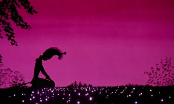 Movie still from “Princes and Princesses” (2000), directed by Michel Ocelot – A woman kneeling on the ground in front of a field of lights; Wide shot, Low angle