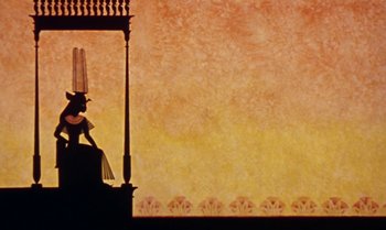 Movie still from “Princes and Princesses” (2000), directed by Michel Ocelot – A silhouette of a woman standing on top of a building; Extreme Wide shot, Low angle