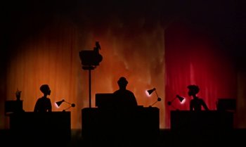 Movie still from “Princes and Princesses” (2000), directed by Michel Ocelot – A silhouette of a man sitting at a desk; Extreme Wide shot, Low angle
