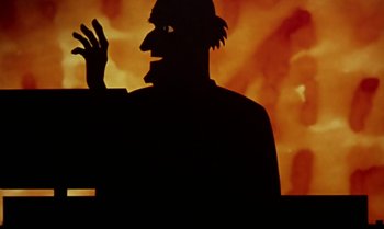 Movie still from “Princes and Princesses” (2000), directed by Michel Ocelot – A silhouette of a man in front of an orange background; Close Up shot, Low angle