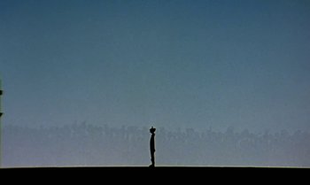 Movie still from “Princes and Princesses” (2000), directed by Michel Ocelot – A man standing on top of a grass covered field; Extreme Wide shot, Low angle