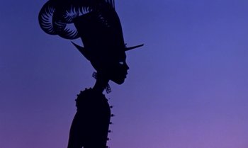 Movie still from “Princes and Princesses” (2000), directed by Michel Ocelot – A silhouette of a person wearing a hat and feathers; Close Up shot, Low angle
