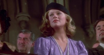 Movie still from “Prizzi's Honor” (1985), directed by John Huston – A woman wearing a purple dress and a black hat; Close Up shot, Low angle