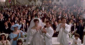 Movie still from “Prizzi's Honor” (1985), directed by John Huston – A large group of people at a wedding; Wide shot, Over the shoulder angle