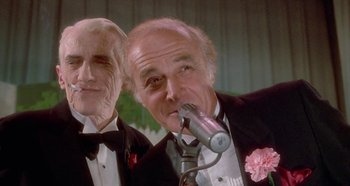 Movie still from “Prizzi's Honor” (1985), directed by John Huston – Two men in tuxedos are standing next to each other; Close Up shot, Low angle