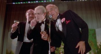 Movie still from “Prizzi's Honor” (1985), directed by John Huston – A group of men in tuxedos standing next to each other; Medium shot, Low angle