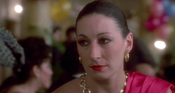 Movie still from “Prizzi's Honor” (1985), directed by John Huston – A person wearing a dress; Close Up shot, Over the shoulder angle