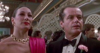 Movie still from “Prizzi's Honor” (1985), directed by John Huston – A man and a woman in formal wear standing next to each other; Close Up shot, Low angle