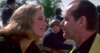 Movie still from “Prizzi's Honor” (1985), directed by John Huston – A man and a woman face to face in front of a crowd; Close Up shot, Over the shoulder angle