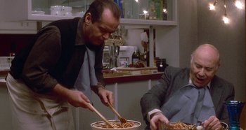 Movie still from “Prizzi's Honor” (1985), directed by John Huston – Two men in a kitchen preparing a pasta dish; Medium shot, Low angle