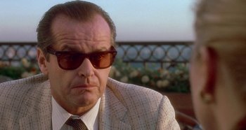 Movie still from “Prizzi's Honor” (1985), directed by John Huston – An older man wearing a suit and sunglasses; Close Up shot, Low angle