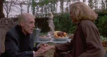 Movie still from “Prizzi's Honor” (1985), directed by John Huston – An older man and a younger woman holding hands; Medium shot, Over the shoulder angle