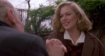 Movie still from “Prizzi's Honor” (1985), directed by John Huston – A woman in a brown jacket shaking a man's hand; Close Up shot, Over the shoulder angle