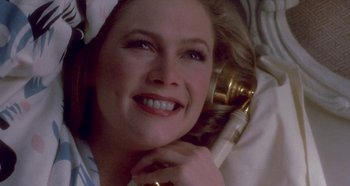 Movie still from “Prizzi's Honor” (1985), directed by John Huston – A person laying on the ground with a phone; Close Up shot, Overhead angle