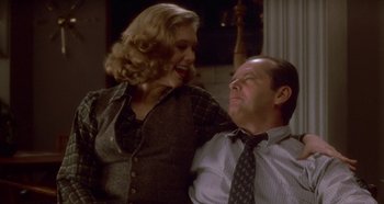 Movie still from “Prizzi's Honor” (1985), directed by John Huston – A man and a woman sitting next to each other; Medium shot, Over the shoulder angle