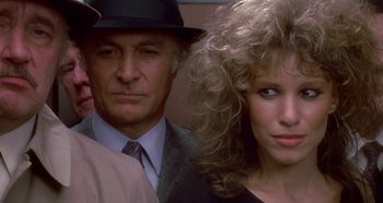 Movie still from “Prizzi's Honor” (1985), directed by John Huston – A man and a woman standing next to each other; Close Up shot, Over the shoulder angle