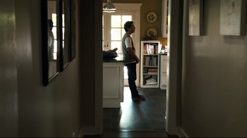 Movie still from “Project X” (2012), directed by Nima Nourizadeh – A man standing in a kitchen looking into a window; Wide shot, Low angle