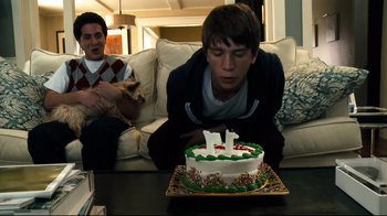 Movie still from “Project X” (2012), directed by Nima Nourizadeh – A boy blowing out the candles on a birthday cake; Medium shot, Over the shoulder angle