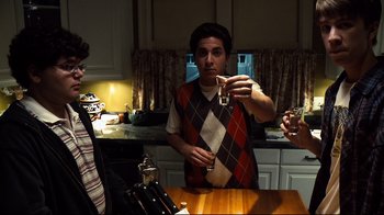 Movie still from “Project X” (2012), directed by Nima Nourizadeh – A man holding a wine glass in a kitchen; Medium shot, Low angle