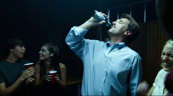 Movie still from “Project X” (2012), directed by Nima Nourizadeh – A man drinking a beer while standing next to a woman; Medium shot, Low angle