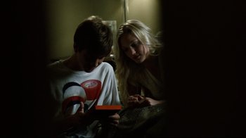 Movie still from “Project X” (2012), directed by Nima Nourizadeh – A woman and a young boy looking at a cell phone; Medium shot, Over the shoulder angle