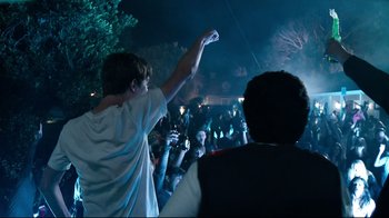Movie still from “Project X” (2012), directed by Nima Nourizadeh – A person holding a game controller in a crowd; Wide shot, Low angle
