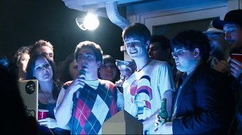 Movie still from “Project X” (2012), directed by Nima Nourizadeh – A group of young men standing around each other at a party; Medium shot, Low angle