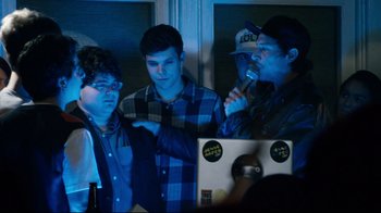 Movie still from “Project X” (2012), directed by Nima Nourizadeh – A group of young men standing next to each other in front of a computer; Medium shot, Over the shoulder angle