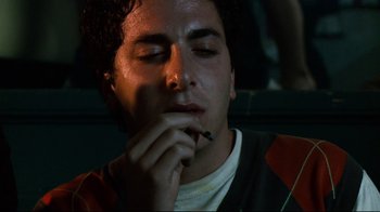 Movie still from “Project X” (2012), directed by Nima Nourizadeh – A young man smoking a cigarette while sitting in a car; Close Up shot, Low angle