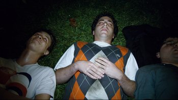 Movie still from “Project X” (2012), directed by Nima Nourizadeh – Two young men laying in the grass at night; Medium shot, Overhead angle