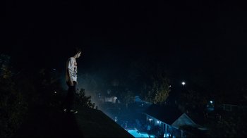 Movie still from “Project X” (2012), directed by Nima Nourizadeh – A man standing on top of a hill at night; Wide shot, Low angle