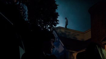 Movie still from “Project X” (2012), directed by Nima Nourizadeh – A man standing on top of a building at night; Wide shot, Low angle