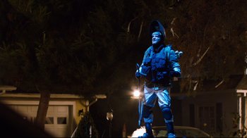 Movie still from “Project X” (2012), directed by Nima Nourizadeh – A man in a blue jacket is standing in front of a street light; Wide shot, Low angle